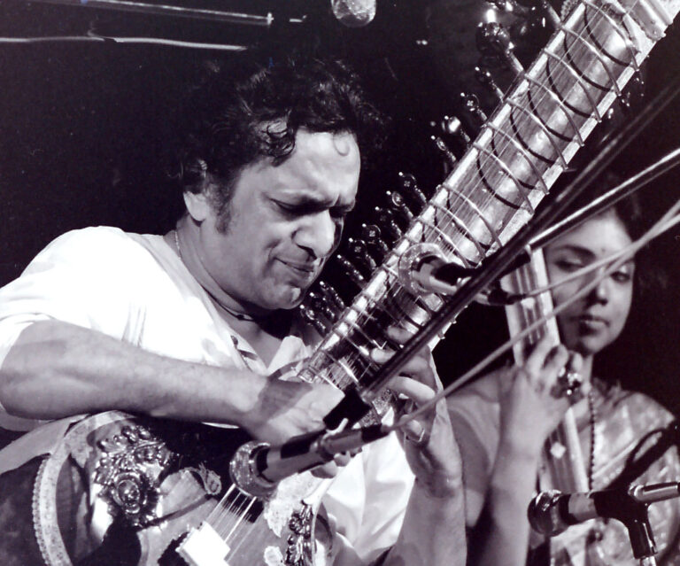 A photo of Pandit Ravi Shankar playing an instrument in concert at Woodstock