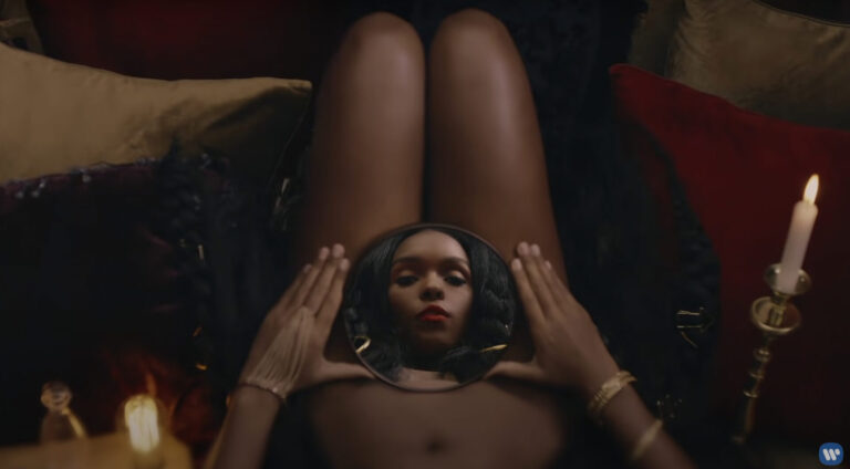 The face of Janelle Monáe, as Jane57821, reflected in a mirror on her lap, as she delivers a "vagina monologue" in "Django Jane."