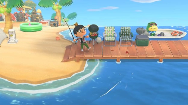 Within the ACNH game, a queer, crip, gender fluid, diasporic Pilipinx character with short black hair, brown eyes, and light brown skin wearing a gold crown, gold glasses, a black cardigan with pink and white flowers, green pants, and tan shoes fishing on a wood pier with a green BBQ, outdoor chairs, and cooler overlooking the blue ocean. A green turtle named Kappa wearing red sunglasses and a blue shirt is nearby lying down a blue boat.