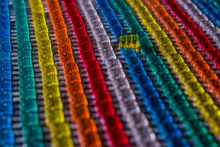 Close-up photo of rows of electrical fuses in rainbow colors.