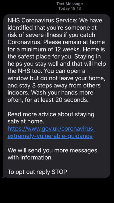 This is a screenshot of a text message, which reads, “NHS Coronavirus Service: we have identified that you’re someone at risk of severe illness if you catch Coronavirus. Please remain at home for a minimum of 12 weeks. Home is the safest place for you. Staying in help you stay well and that will help the NHS too. You can open a window but do not leave your home, and stay 3 steps away from others indoors. Wash your hands more often, for at least 20 seconds. Read more advice about staying safe at home. https://www.gov.uk/coronavirus-extremely-vulnerable-guidance. We will send you messages with more information. To opt out, reply STOP.”