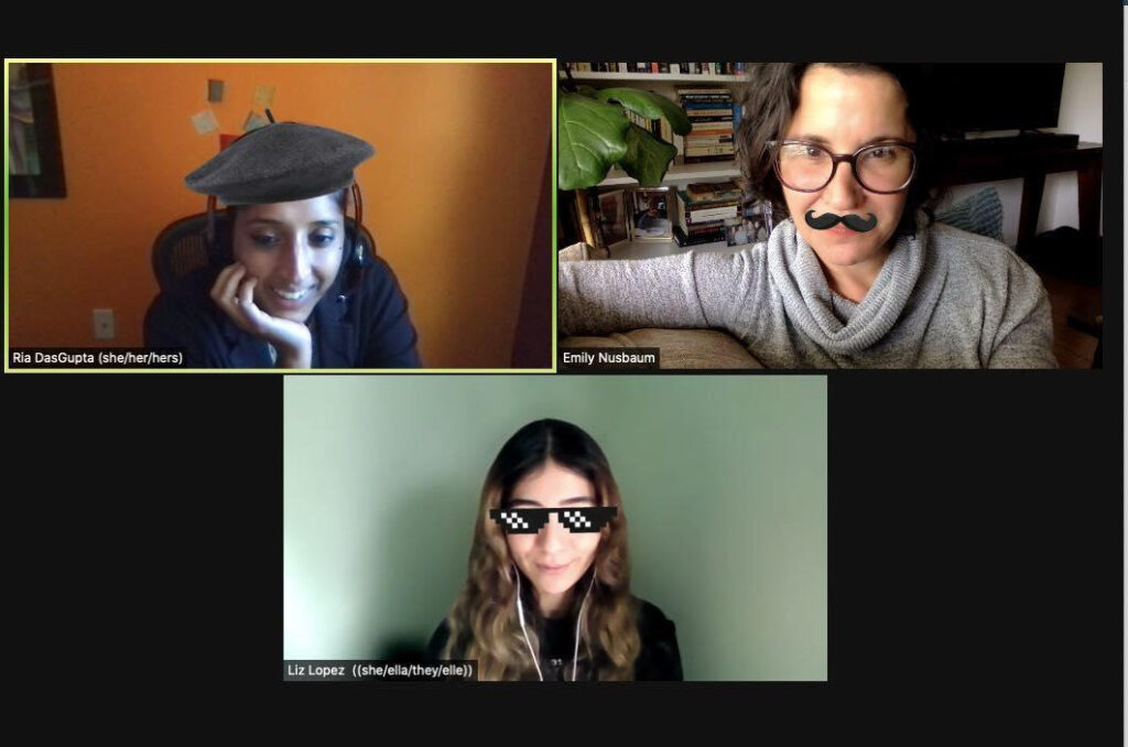 The image is a screenshot of a zoom meeting. Ria DasGupta (she/her pronouns) (top left), Emily Nusbaum (she/her pronouns) (top right) and Liz Lopez (she/her/they/elle pronouns) (bottom center) are pictured inside their respective zoom box. Ria is holding her face tenderly with a smile and wears a gray hat filter. Emily is in a relaxed position using the black mustache filter. Liz looks forward with a small grin wearing the black sunglasses filter. They all enjoy the moment to be in community with each other through the zoom platform.