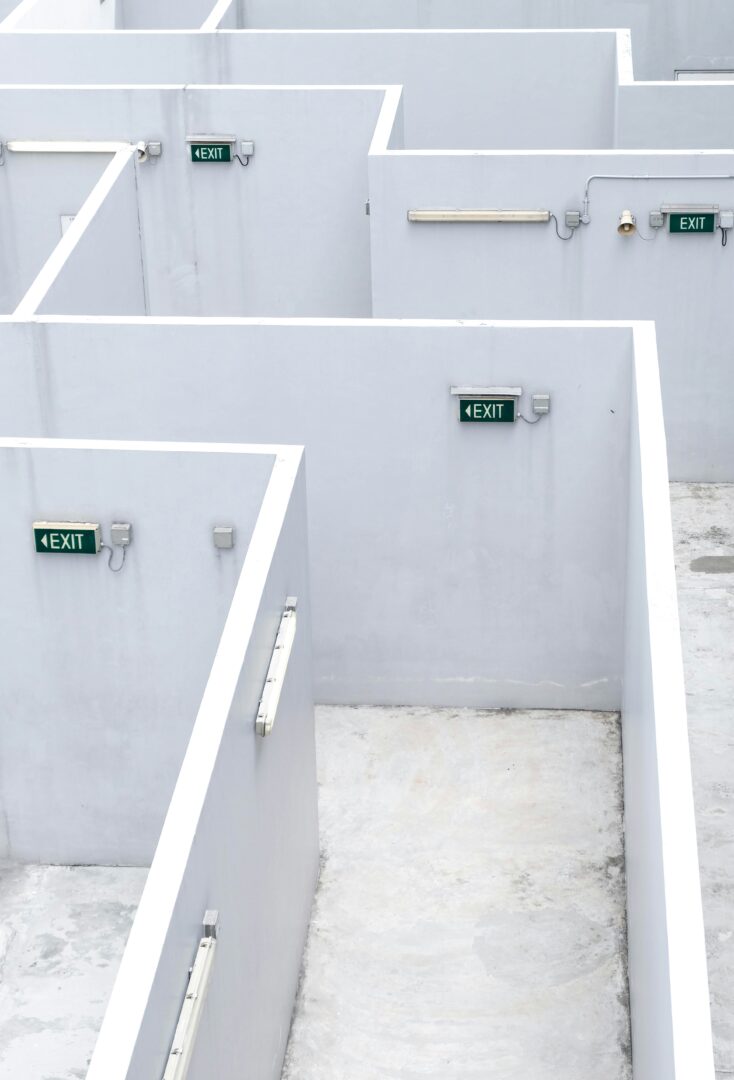 White concrete maze with Exit signs pointing in different directions