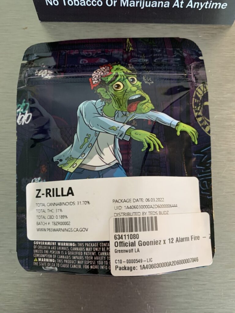 The package for the strain “Z-Rilla” features a green cartoon zombie with exposed brain, wearing blue jeans, a white t-shirt, and a blue work shirt.