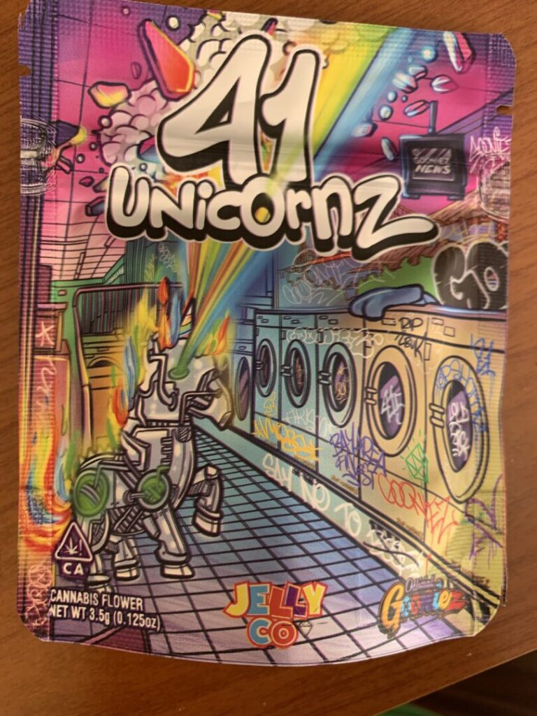 The package for “41 Unicornz” shows a metallic unicorn blasting rainbow-colored rays through the ceiling above a graffiti covered bank of laundromat washing machines. 