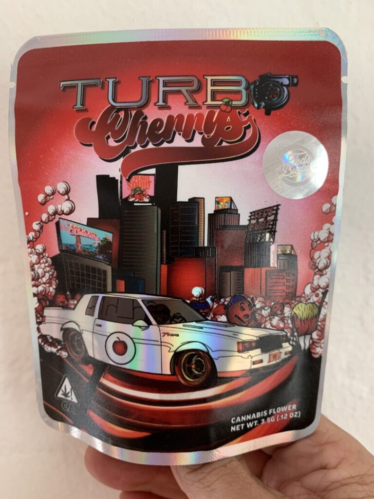 The cannabis package foregrounds an image of a white muscle car in front of a city skyline and under a cherry-red sky.