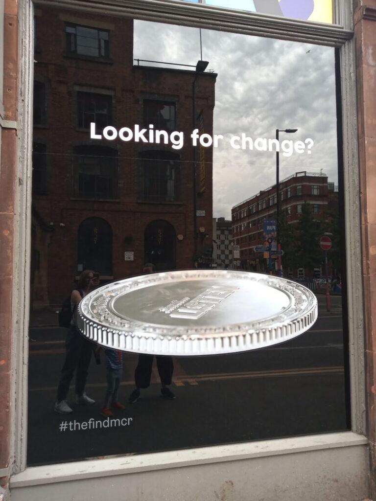 A poster bearing the legend 'Looking for change?' and an image of a silver coin