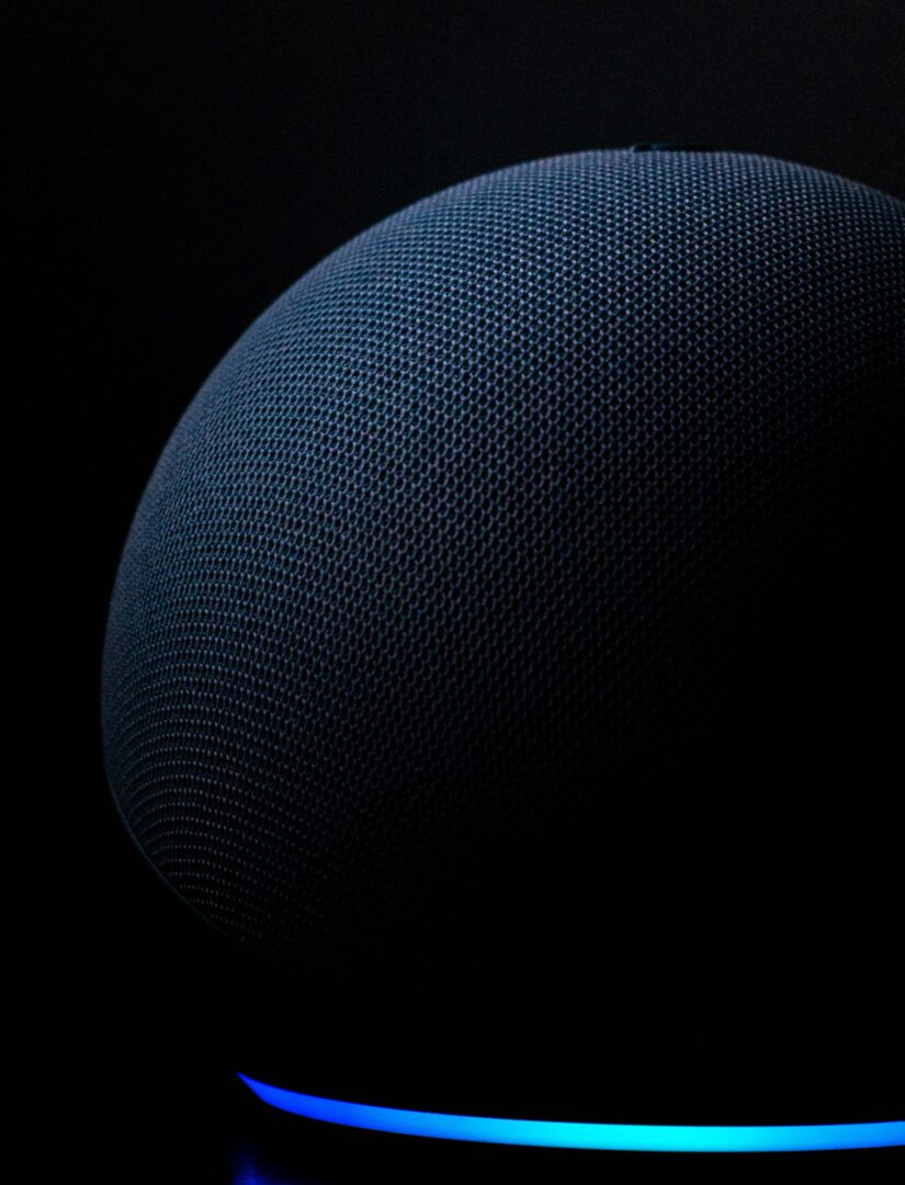 Dark photo of an Alexia device with a glowing blue/green base.