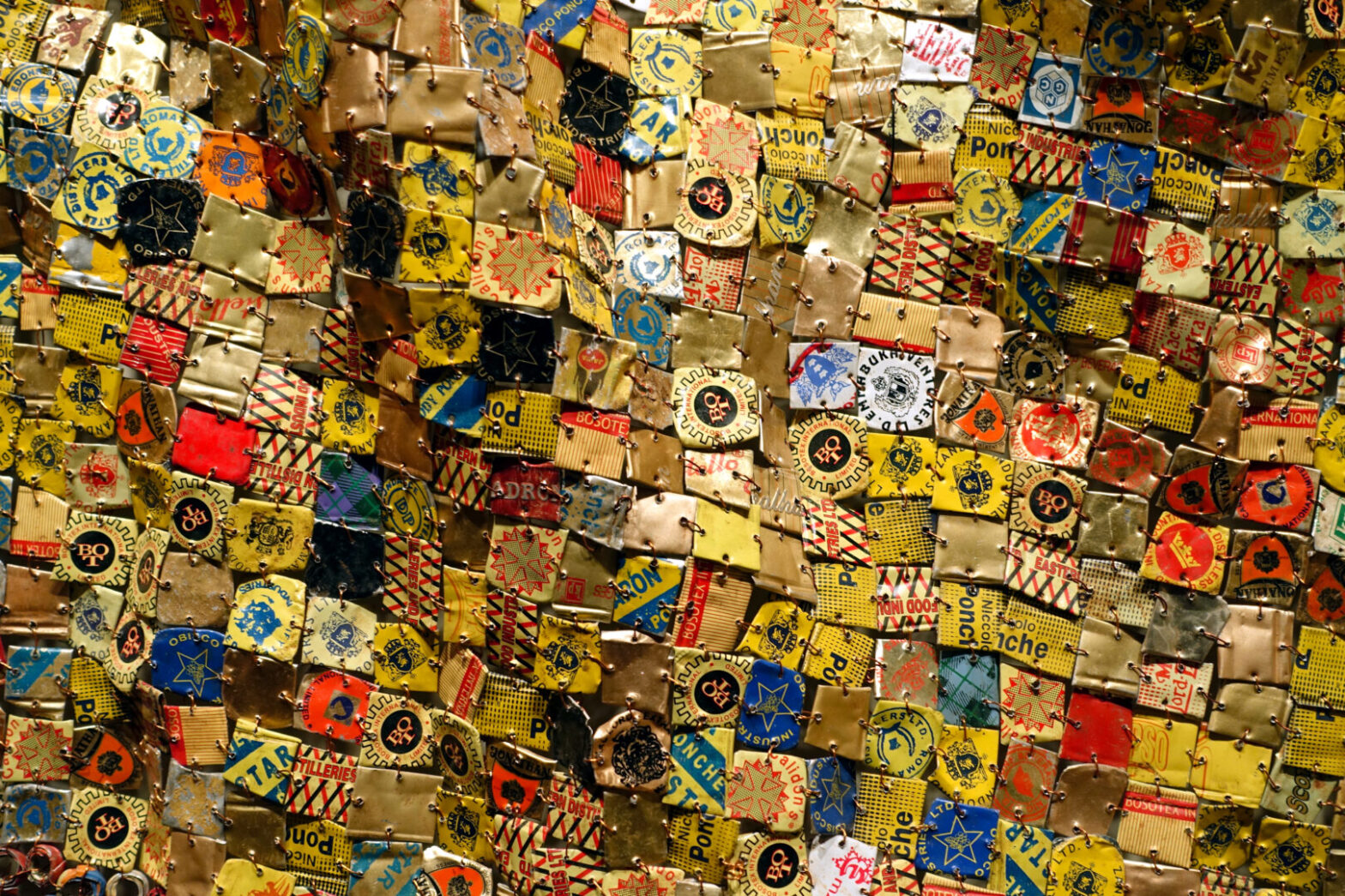 Photo of El Anatsui's "Many Came Back. Aluminum liquor bottle tops and copper wire, 84 x 115 inches (Newark Museum)
