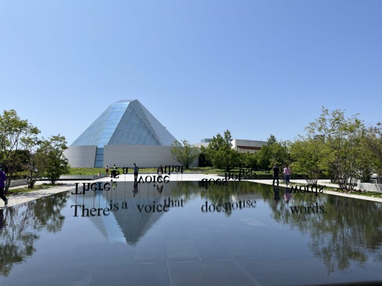 Photo of the center and reflecting pool. A display reads, "There is a voice that does not use words."